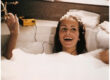 Woman in a bathtub listening to a Walkman.